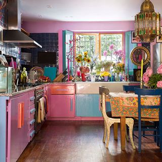 kitchen and dining area with pink wall and pink cabinets