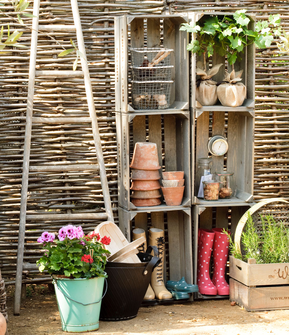 garden area with willow fence and potted plants