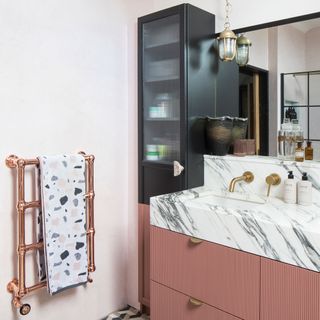 Black and pink bathroom with patterned tiled floor and tall ikea cabinet turned into bathroom storage