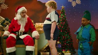 Bad Santa -elokuvan pukki ja tonttu nuoren pojan kanssa