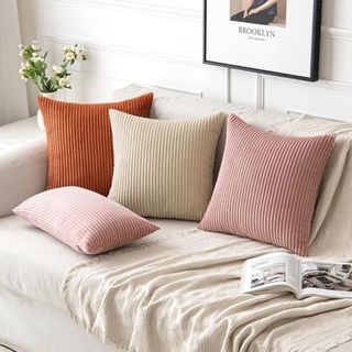 Three colorful throw pillows on a sofa