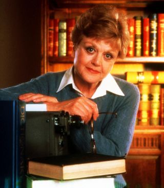 angela landsbury poses in a study in a promotional shot for murder she wrote