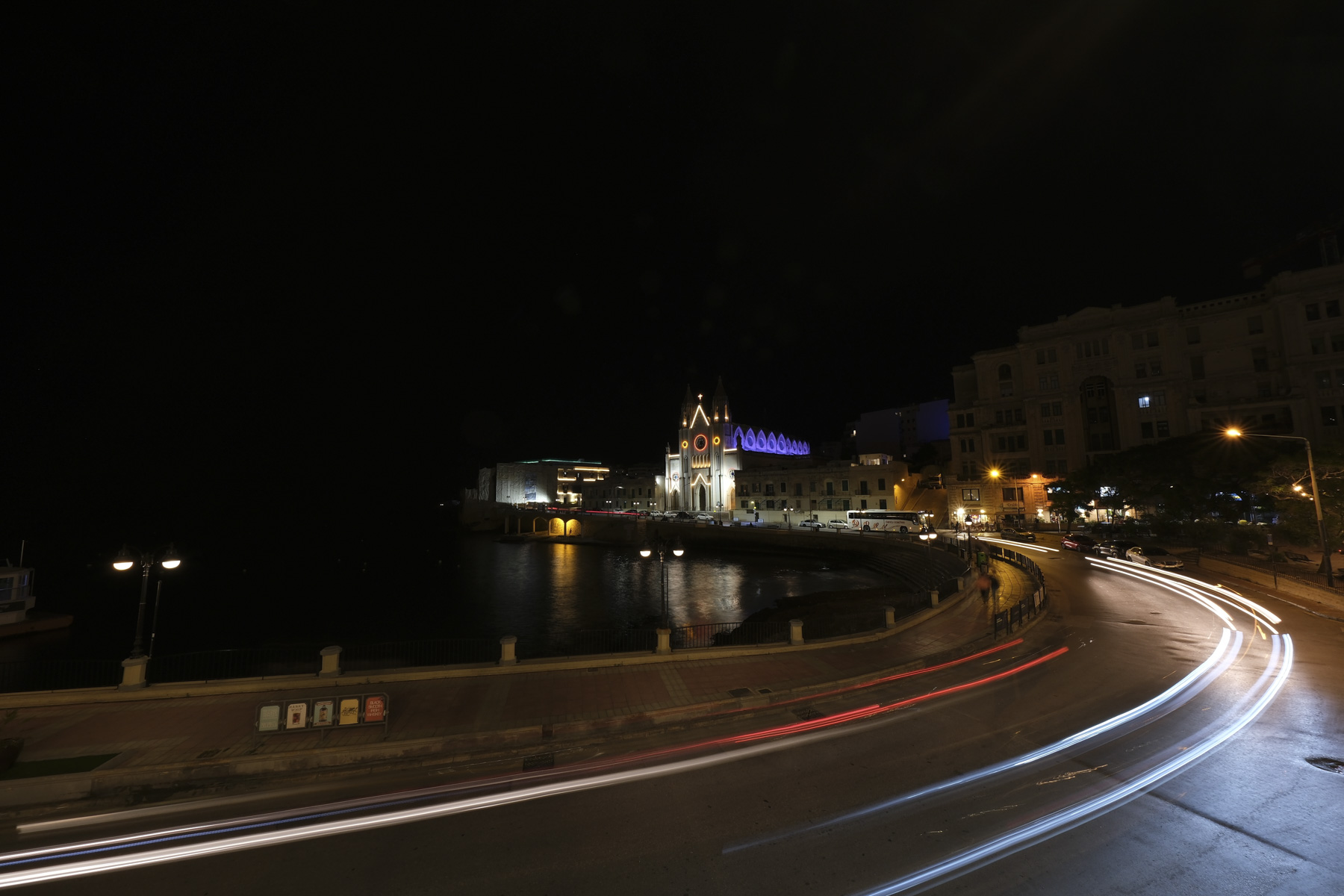 Light trails on a road curving on the seaside front