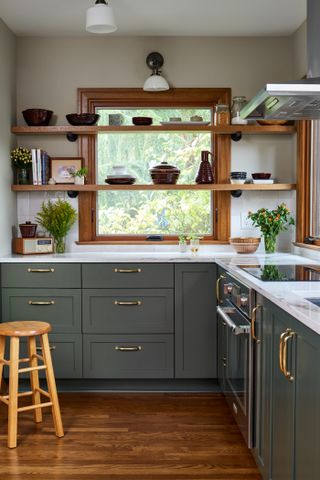 Small kitchen with shelving across windows