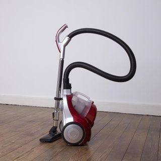 room with white wall vacuum cleaner and wooden flooring