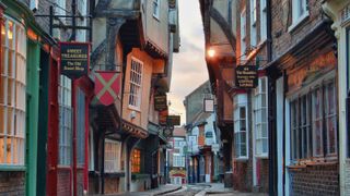 A high-street in York with old shop signs and Tudor buildings