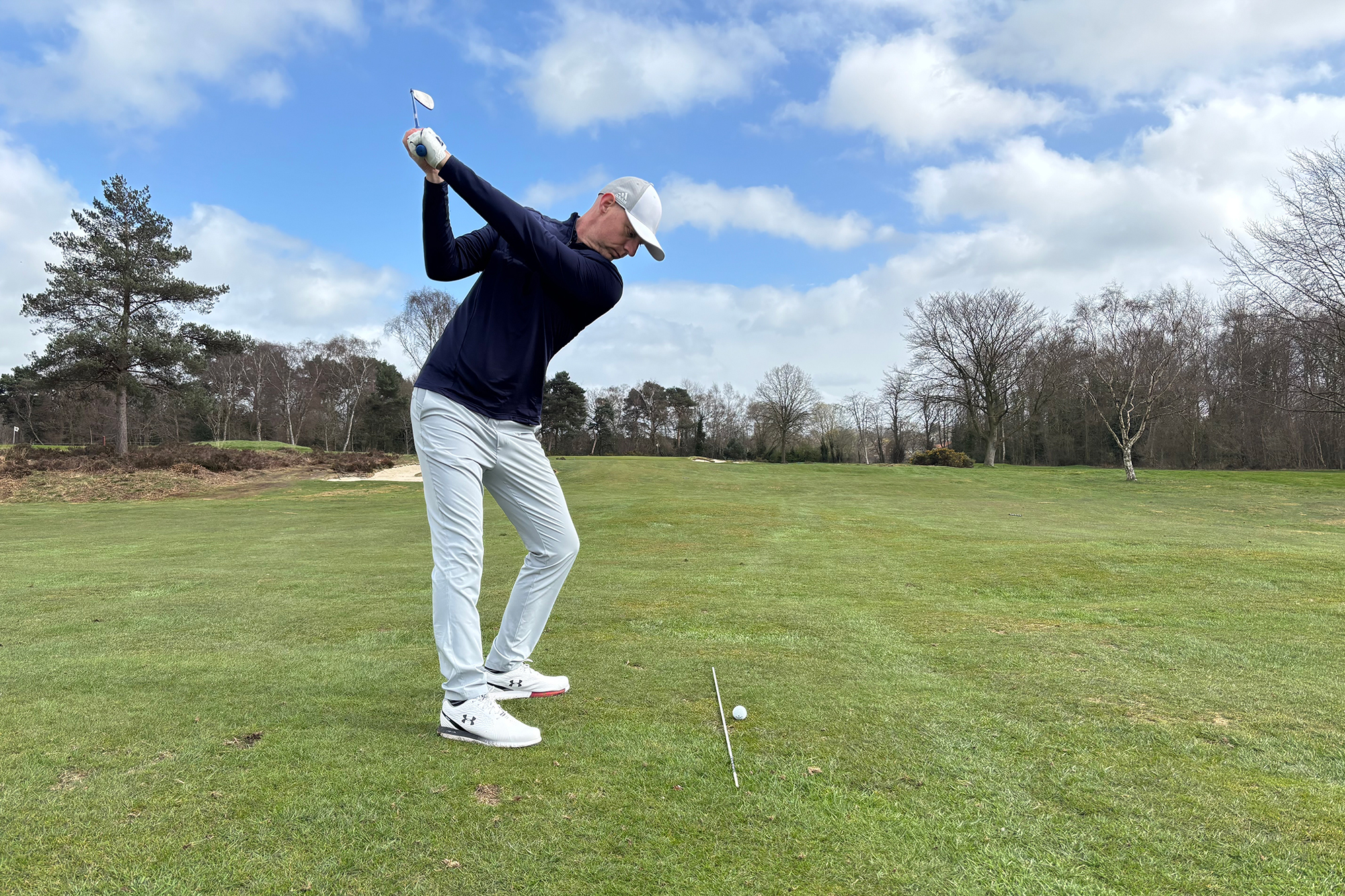 Top 50 Coach Ged Walters aiming away from the bunker guarding the pin, shown by an alignment stick on the ground, instead aiming for the left side for safety