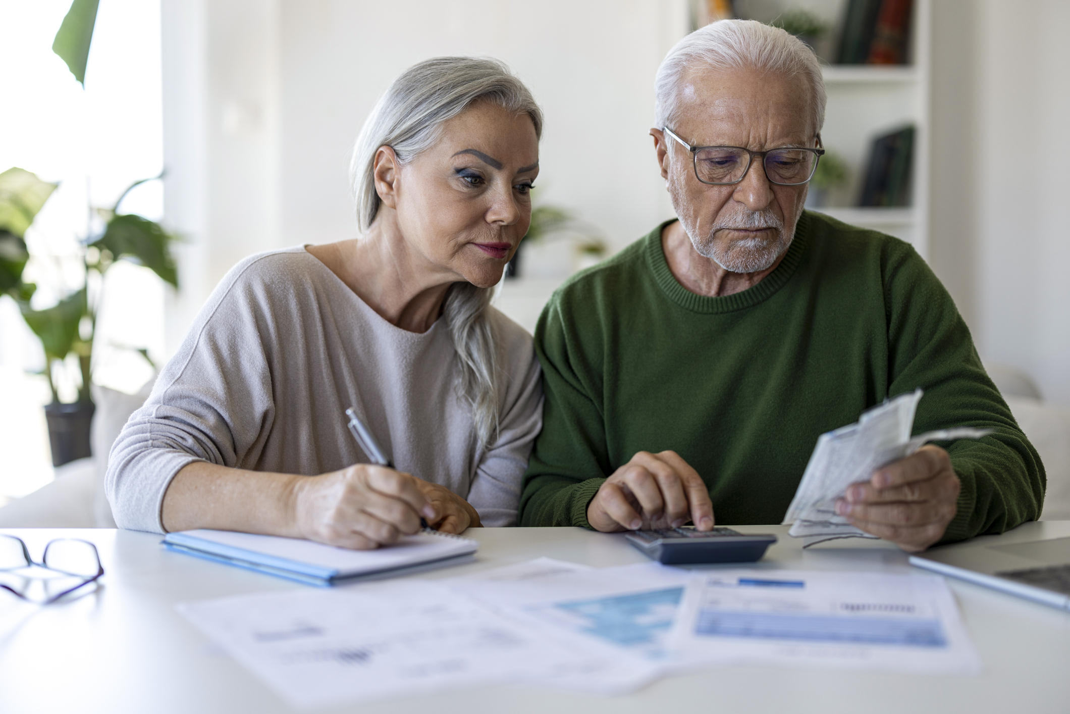 Senior Couple Calculating Household Expenses and Reviewing Bills at Home