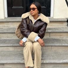 Girl in coat and beiege pants with suede bag