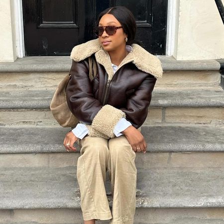 Girl in coat and beiege pants with suede bag