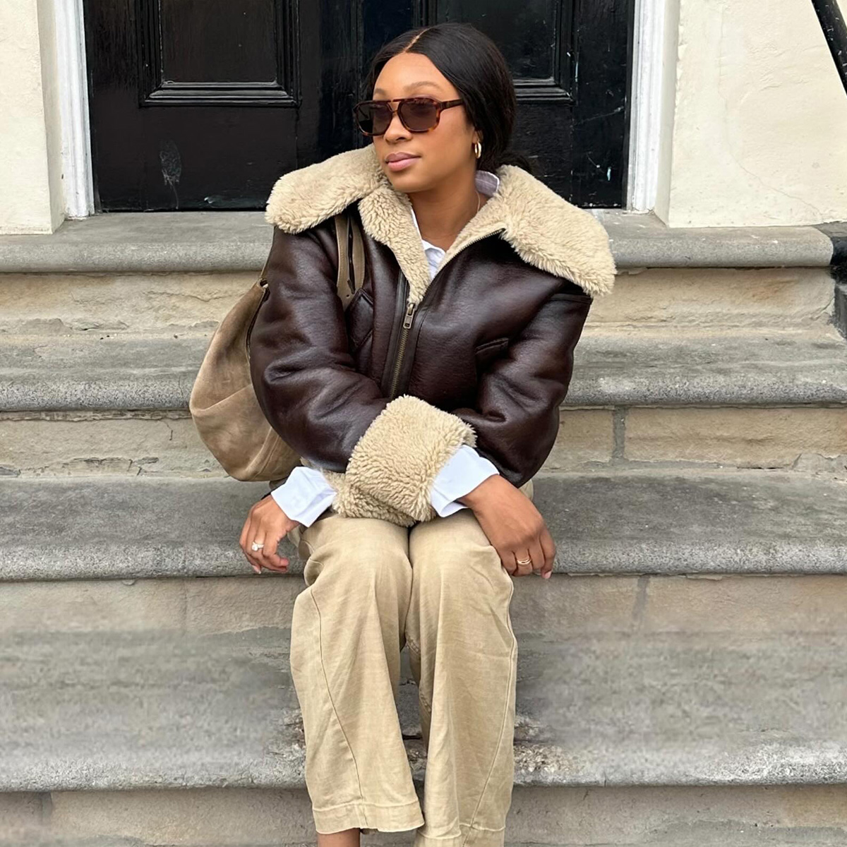 Girl in coat and beiege pants with suede bag