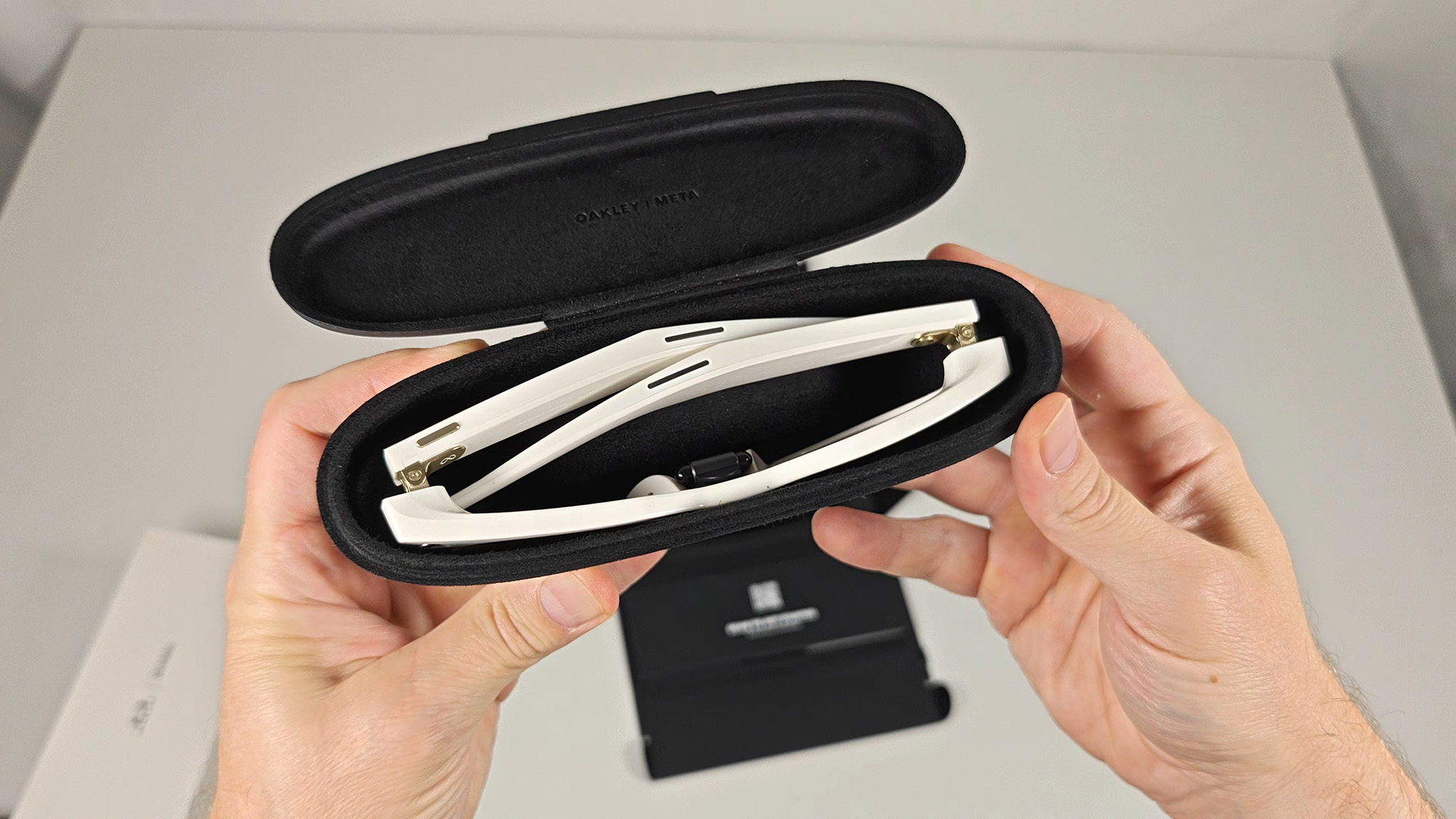 Comparing the size and shape of Ray-Ban Meta Smart Glasses and Oakley Meta HSTN's charging cases