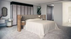 A large bedroom with a soft area rug, a wood bed frame with an attached headboard featuring wall sconces and bedside drawers, a vanity with a mirror and a plush seat, and a section of cupboards