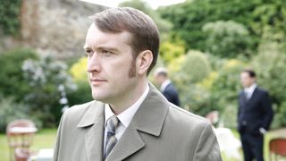 Sean Rigby in a light jacket as DS Jim Strange in Endeavour.