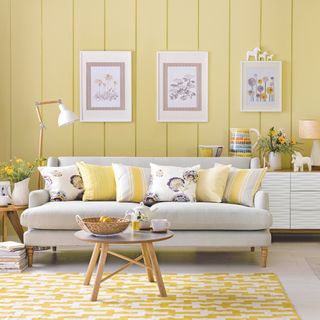 living room with yellow wall and yellow pillows on sofa