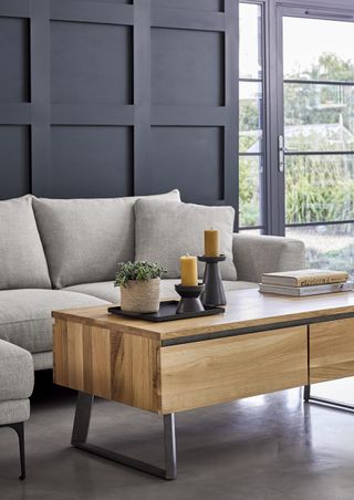a wood coffee table in a modern grey living room with sofa
