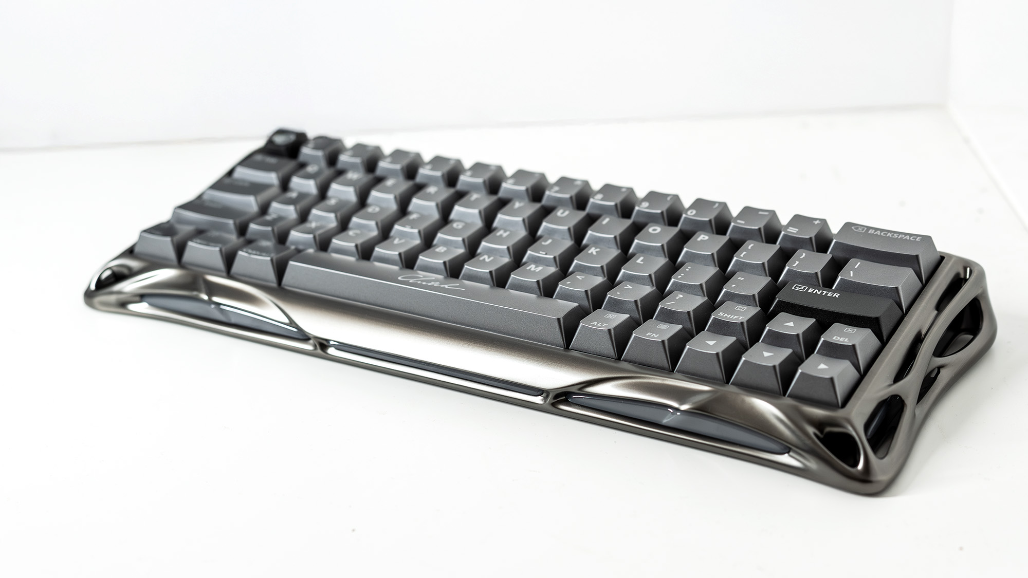 A Gravastar Mercury V60 Pro gaming keyboard with a shiny aluminium shell on a white desk.