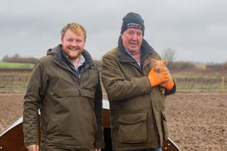 Clarkson's Farm season 3 stars Caleb and Jeremy holding a piglet