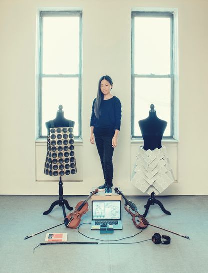 Pauchi Sasaki in Harlem, New York, with her wearable sound sculptures. Also pictured is equipment including an acoustic violin and a self-designed instrument