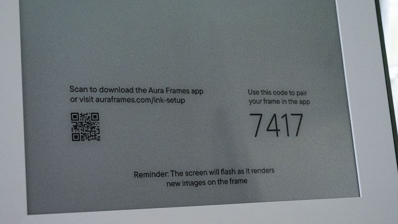 A closeup of the Aura Ink 'E Ink' digital photo frame's display, in pairing mode