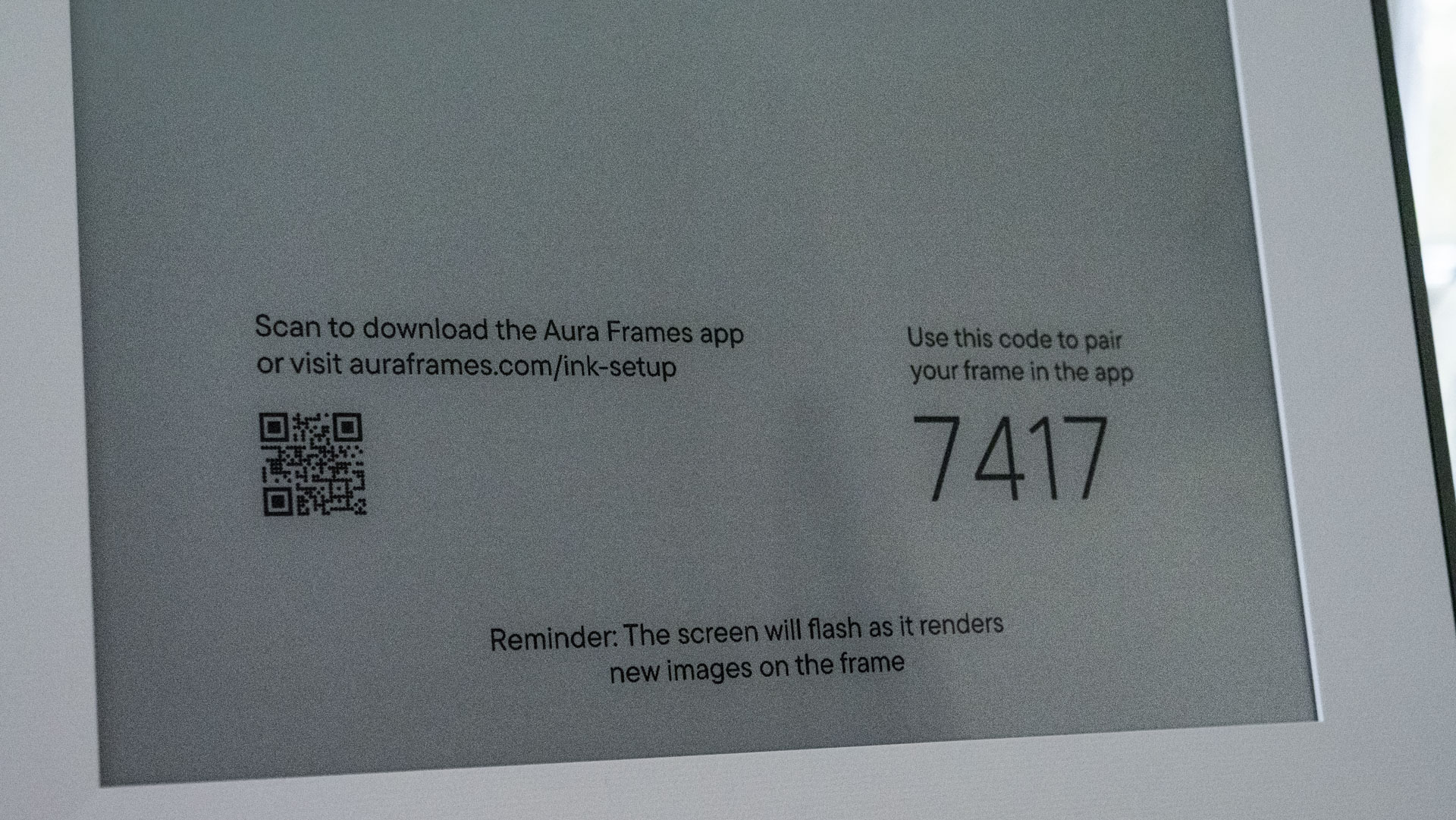 A closeup of the Aura Ink 'E Ink' digital photo frame's display, in pairing mode