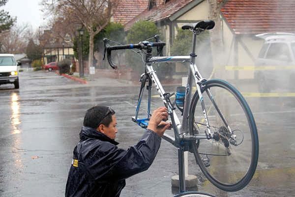 Vince Gee cleans the bikes after a five hour ride in the rain.