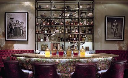 Bar counter with chairs and art work on walls at Coya restaurant - London, UK