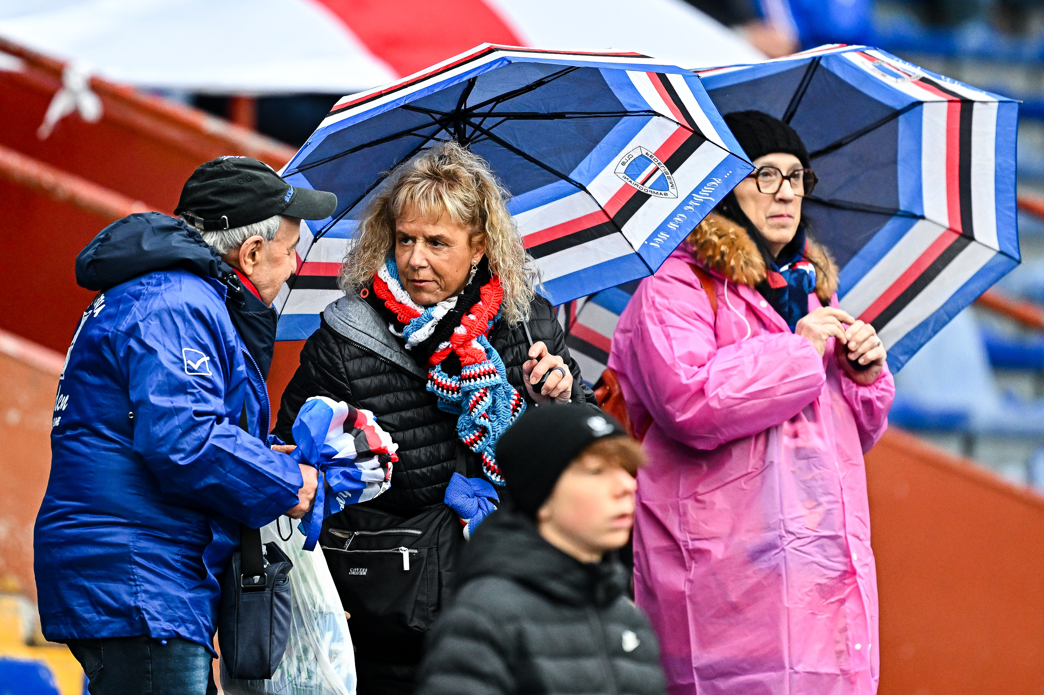 Sampdoria fans holding umbrellas in the rain