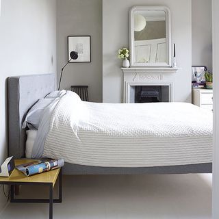 bedroom and grey headboard and white wall