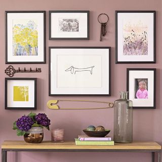 Hallway console table with picture frames on the wall