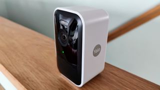 Yale Smart Outdoor Camera review: security camera shot from the side on a wooden shelf