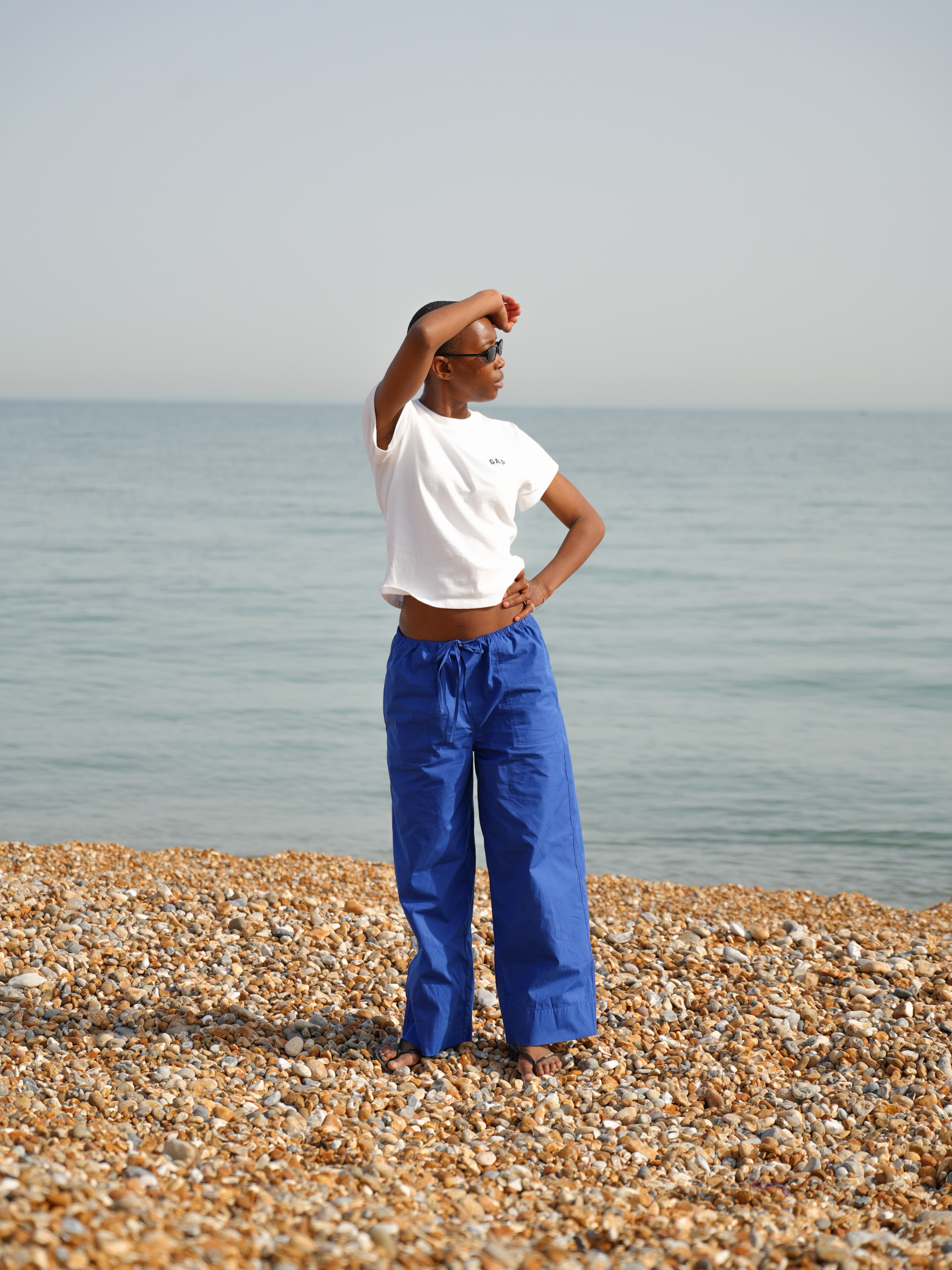 Woman wears white T-shirt, blue trousers