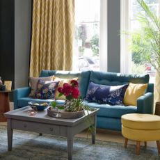 Navy blue sofa with yellow curtains