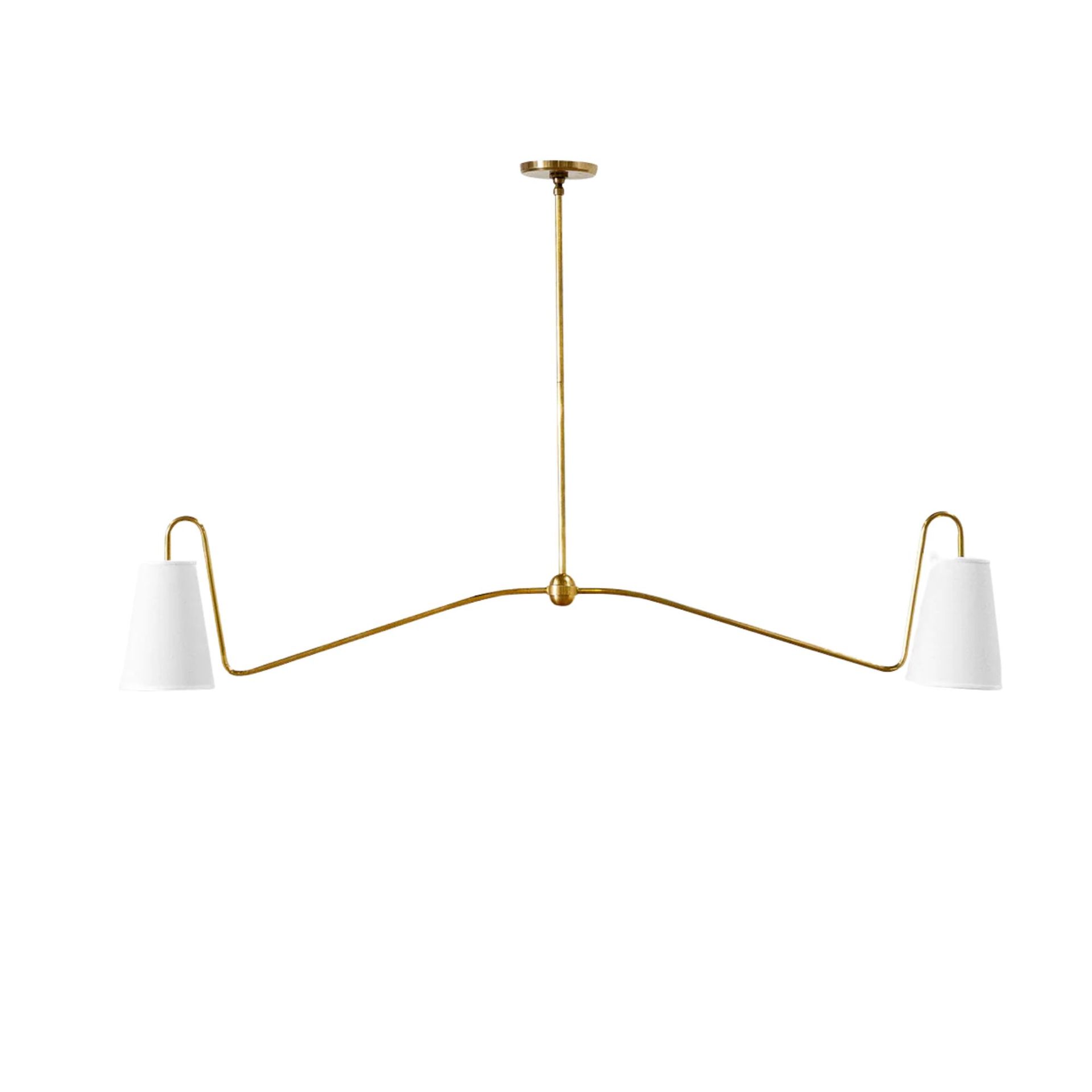 A gold pendant chandelier with two white light shades on either end