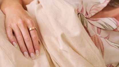 A woman sleeping while wearing the Evie Ring on her finger