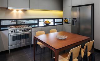 A contemporary kitchen on the lower floor is connected to the dining area with a glass pass-through