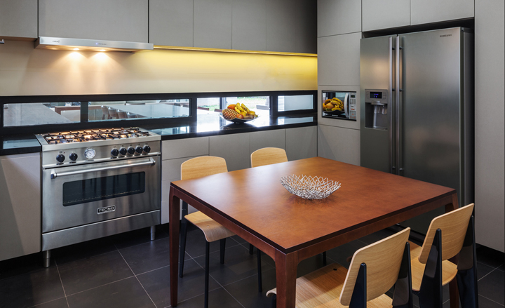 A contemporary kitchen on the lower floor is connected to the dining area with a glass pass-through