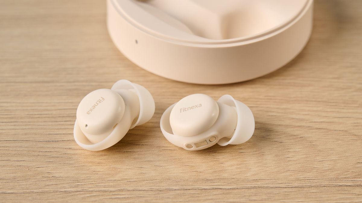 A close up of the Fitnexa SomniPods 3 ear buds on a table, with the open case in the background