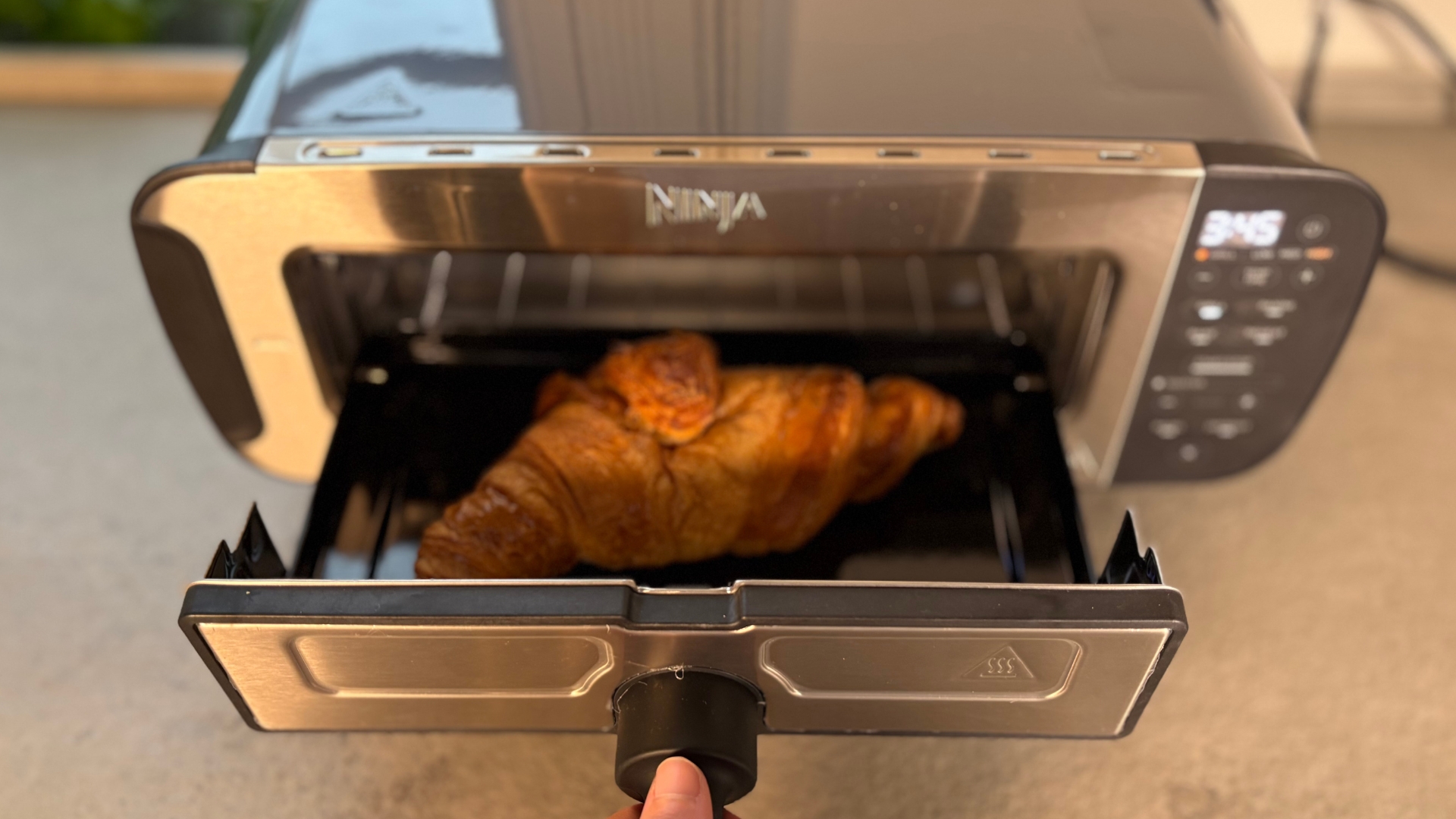 Testing the Ninja Foodi 3-in-1 Toaster Grill Panini Press on the counter baking a croissant