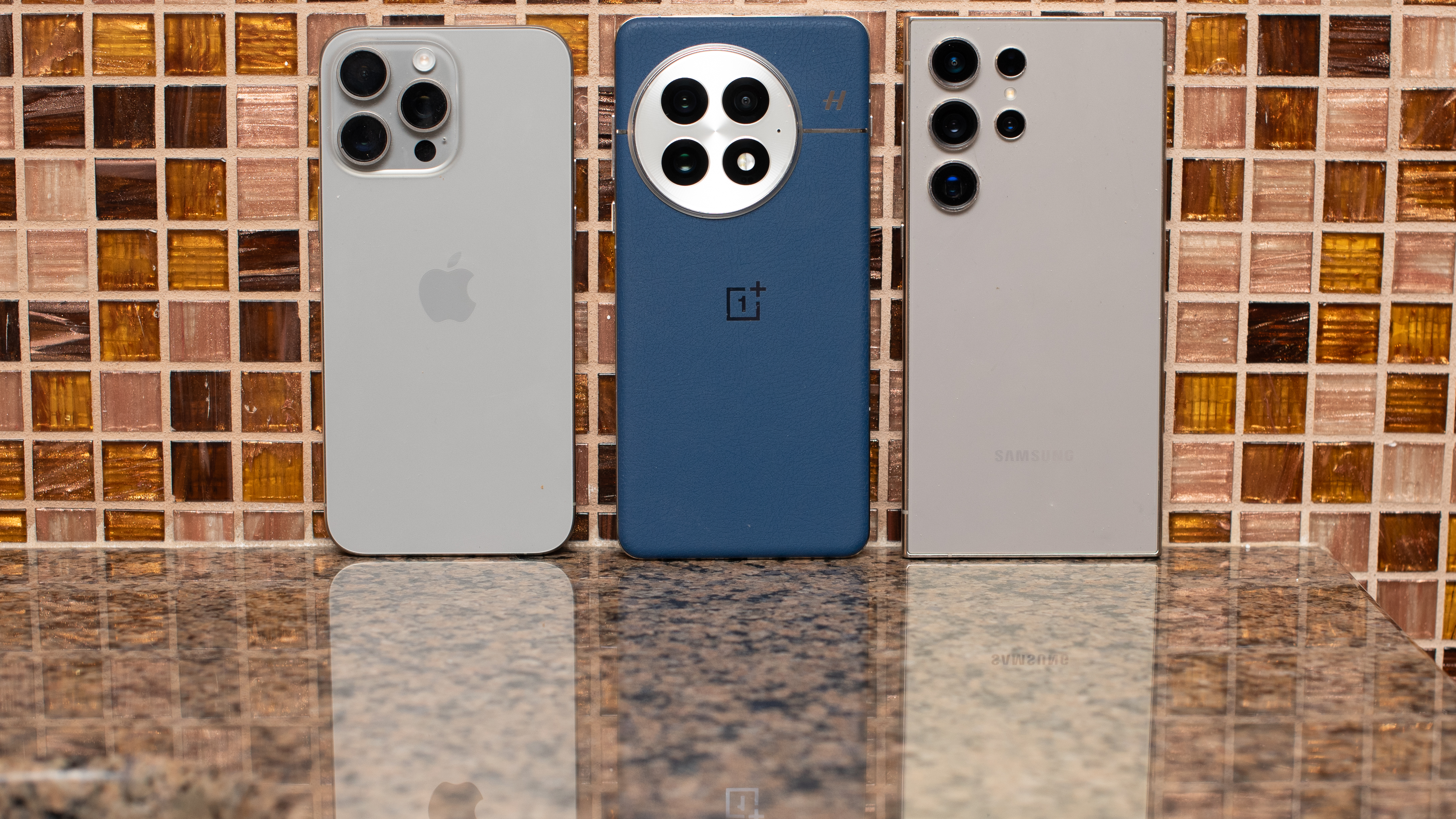 OnePlus 13 in blue in between iPhone 15 Pro Max and Galaxy S24 Ultra