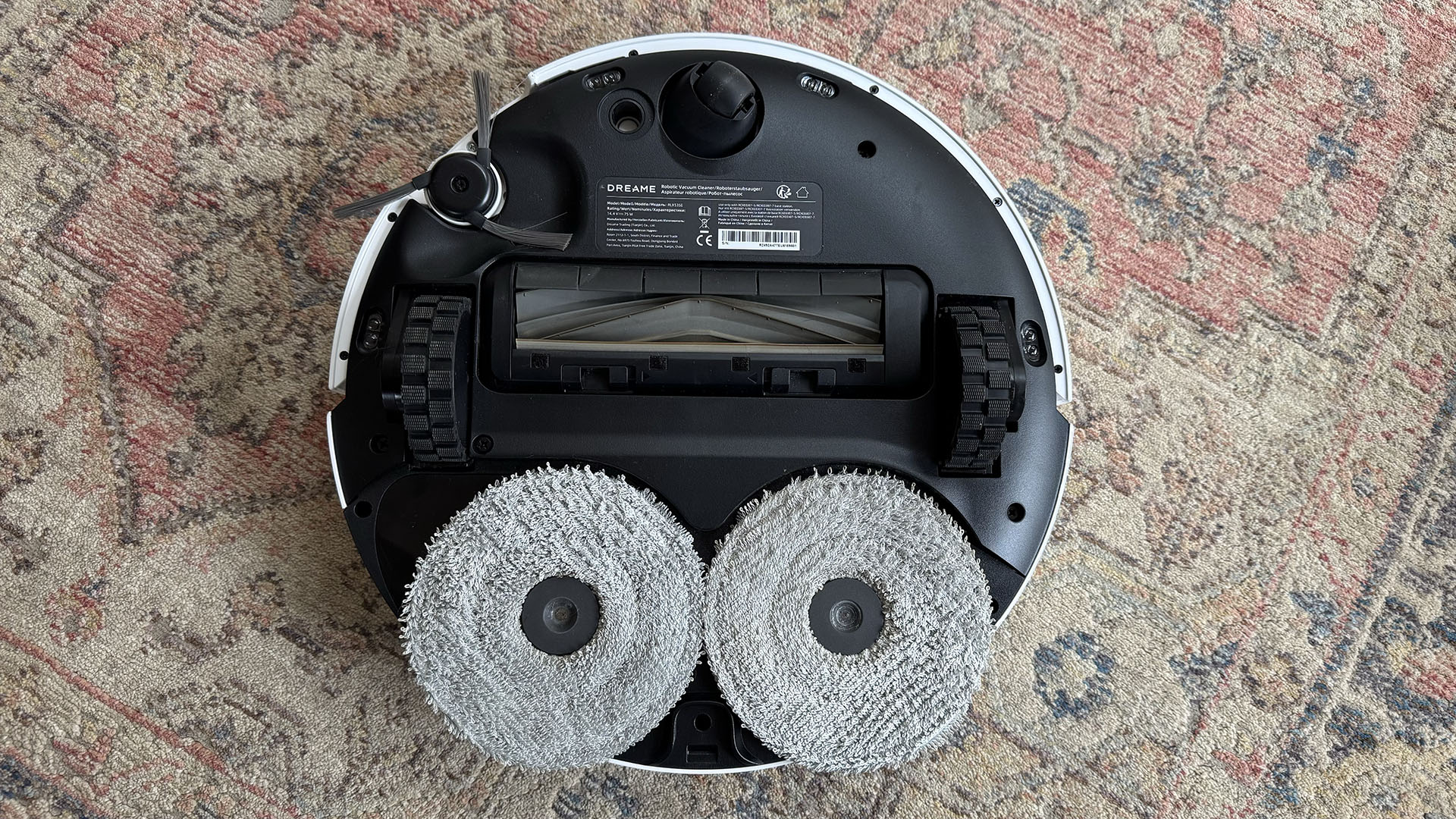 Dreame L40 Ultra robot vacuum flipped over to show mop pads, roller and side brush