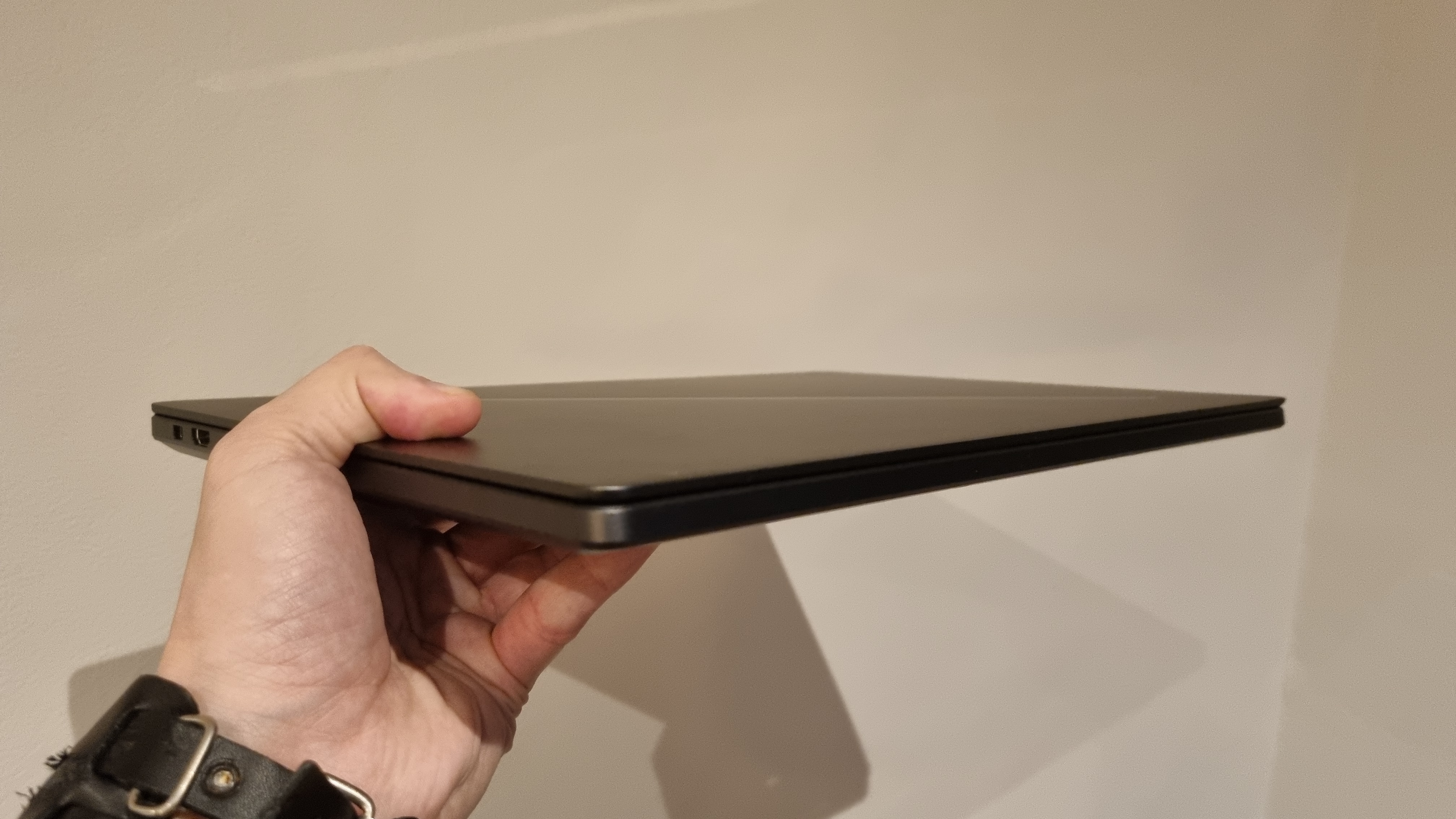 The Asus ROG Zephyrus G16 held in one hand to demonstrate the light weight and slim form factor