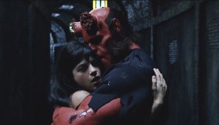 Selma Blair and Ron Perlman share an embrace in a tunnel in Hellboy.