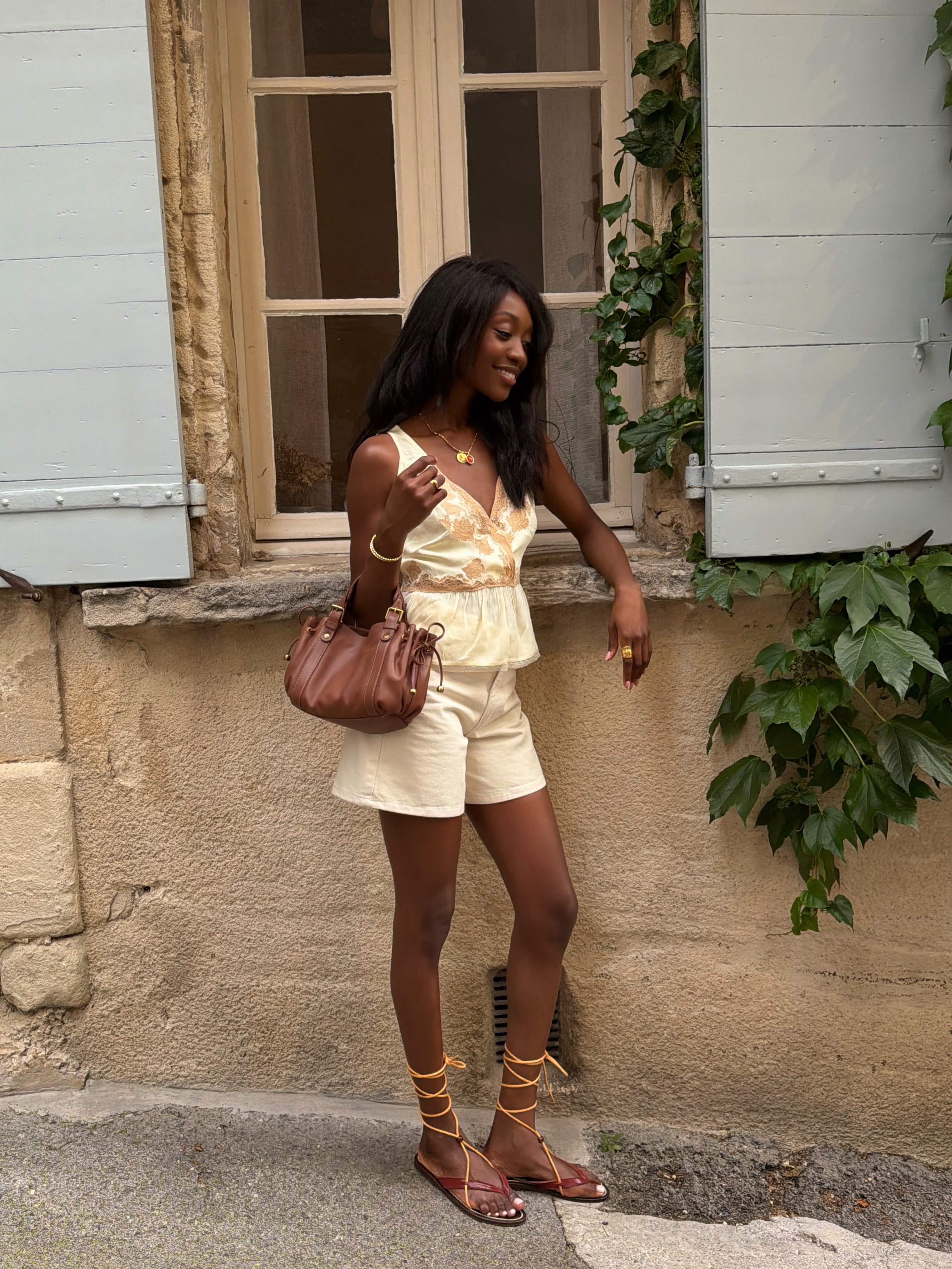 Influencer Emmanuelle Koffi wearing wearing gladiator sandals.