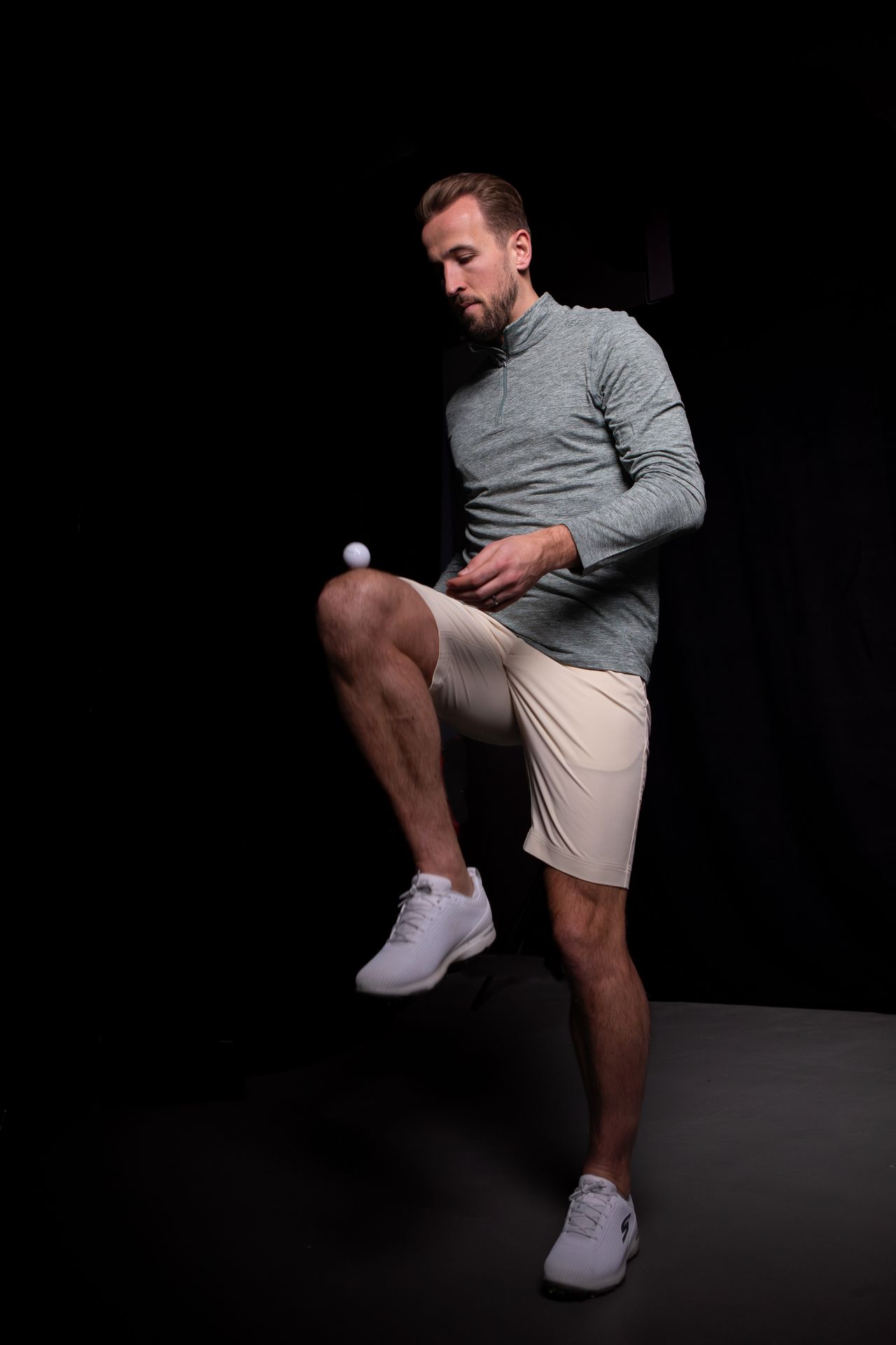 Harry Kane balancing a golf ball on his thigh wearing the latest Reflo golf apparel