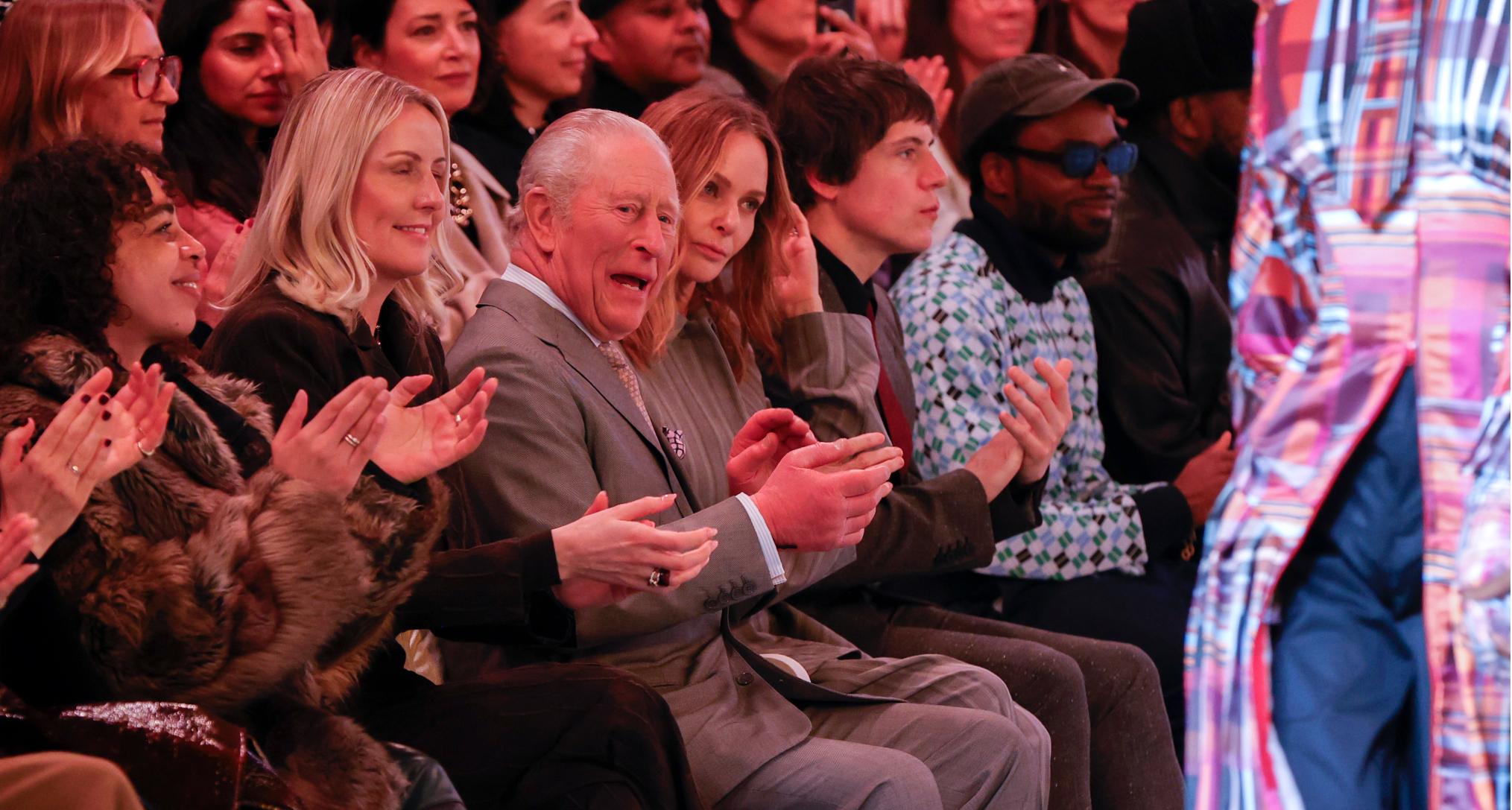 King Charles sitting in the front row at a fashion show