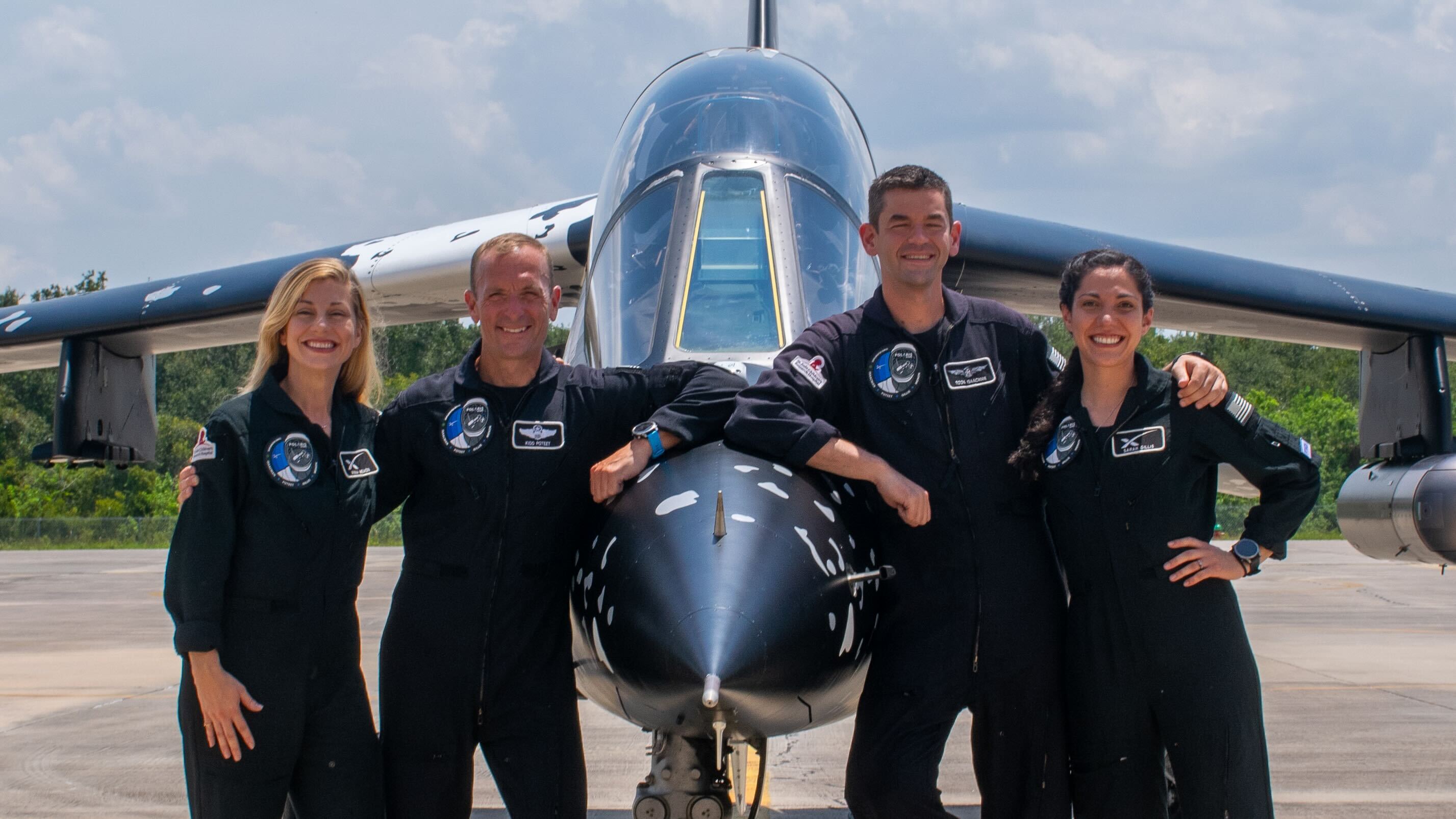 NASA Space Technology Four people in dark jumpsuits lean on a jet.