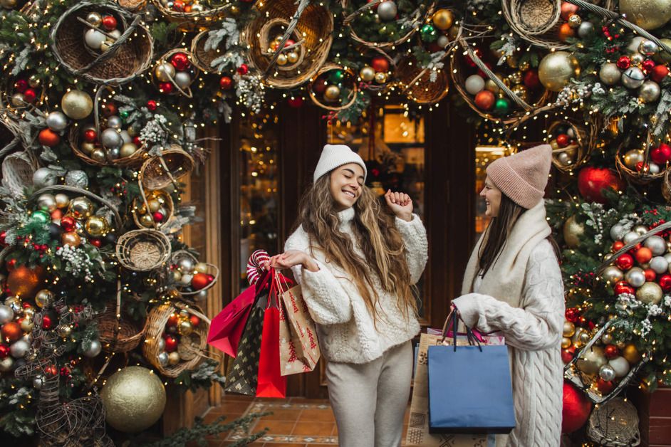 Two women are smiling whilst Christmas shopping 