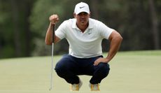 Koepka lines up his putt on the 18th green