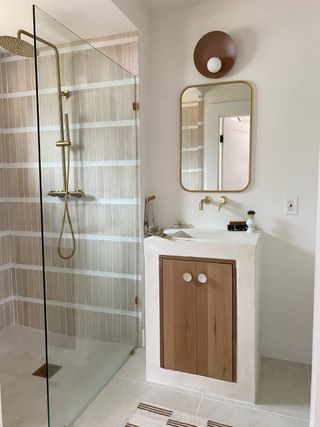 A shower with pink rectangular tiles with oversized grouting